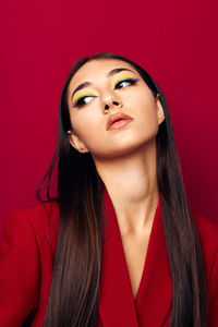 Portrait of young woman against yellow background