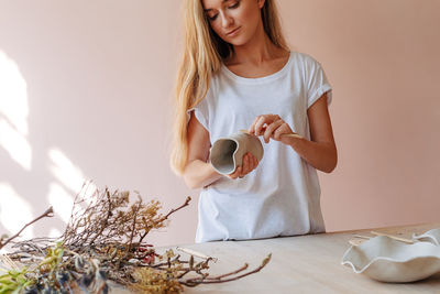 Midsection of woman holding ice cream at home