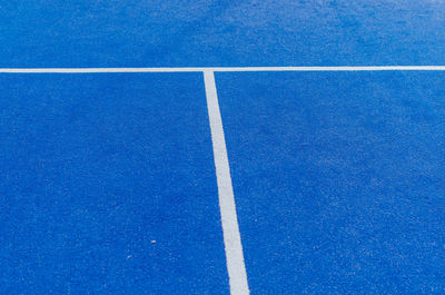 White lines of a blue paddle tennis court. racket sports concept