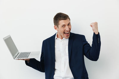 Side view of businessman using laptop against white background