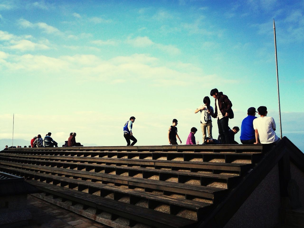 men, lifestyles, sky, large group of people, person, leisure activity, low angle view, steps, railing, cloud - sky, architecture, built structure, walking, steps and staircases, staircase, cloud, full length, mixed age range, togetherness