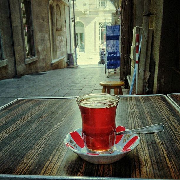 table, indoors, drink, food and drink, architecture, built structure, refreshment, wood - material, still life, building exterior, empty, absence, no people, sunlight, chair, window, day, drinking glass, focus on foreground, close-up