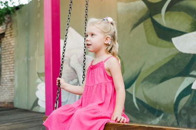 Portrait of young woman sitting on swing