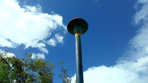 Low angle view of trees against blue sky