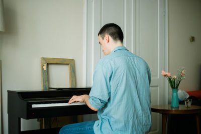 Side view of young woman sitting at home