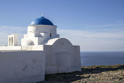 Lighthouse by sea against sky