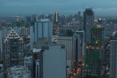 Aerial view of illuminated buildings in city against sky