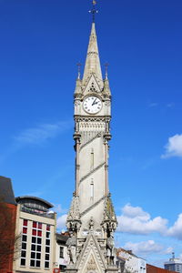 Low angle view of clock tower against blue sky