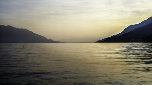 Scenic view of sea and mountains against sky