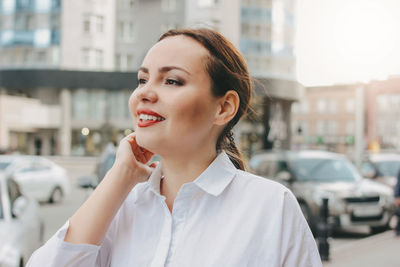 Portrait of smiling young woman in city