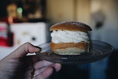 Close-up of hand holding dessert in plate