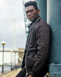 Portrait of young man standing in city