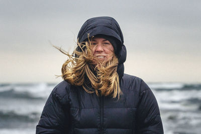 Portrait of smiling woman against sea