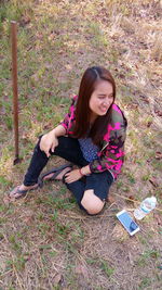 High angle view of young woman sitting on land