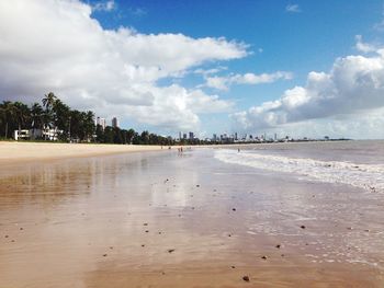 Scenic view of beach against cloudy sky