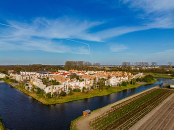 Aerial view of a peaceful suburban neighborhood surrounded by fields and canals. neat rows of houses