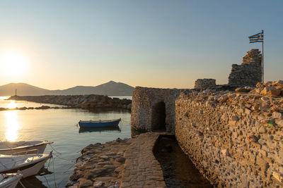 Panoramic view of sea and buildings against sky during sunset