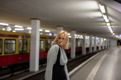 Portrait of woman standing at railroad station platform