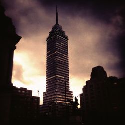 Low angle view of buildings against cloudy sky