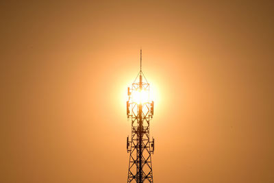 Low angle view of communications tower against sky during sunset