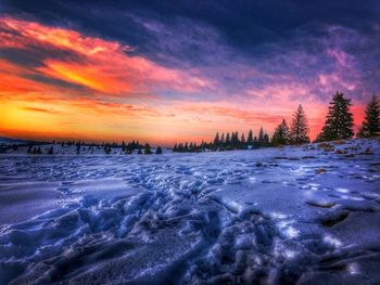 Scenic view of frozen landscape against orange sky