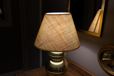 Close-up of illuminated lamp on table at home
