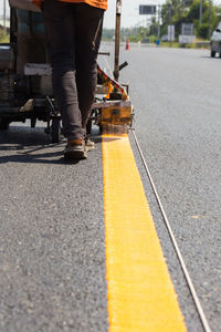 Low section of man walking on road