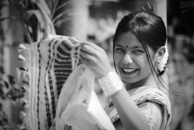 Portrait of smiling young woman holding plant