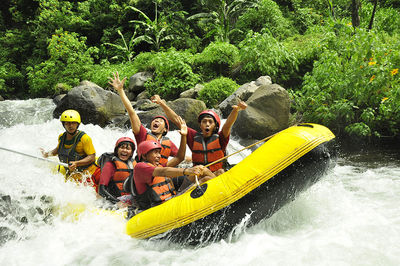 People in boat against river