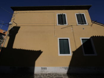 Low angle view of yellow building against sky