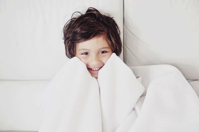 Portrait of smiling girl sitting in bed