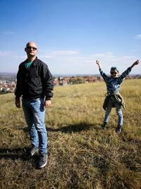 Portrait of father and son standing on hill