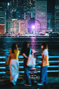 People on illuminated cityscape at night