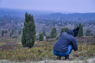 Rear view of man on field against sky