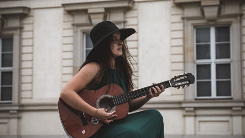 Midsection of woman playing guitar