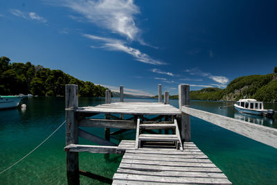 Pier by swimming pool against sky