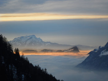 Scenic view of snowcapped mountains against sky during sunset