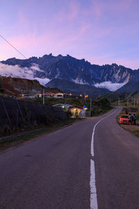 Road by mountain against sky