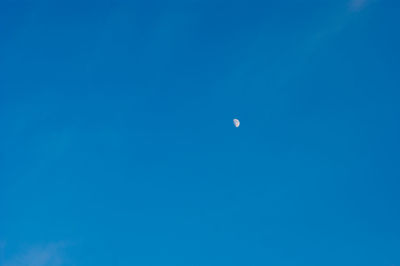 Low angle view of moon against blue sky