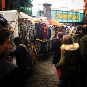 Rear view of people walking on street in city