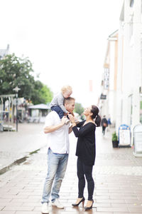 Rear view of couple walking on footpath