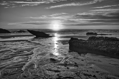 Scenic view of rocks on beach against sky