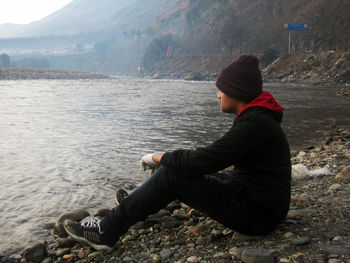 Man sitting by lake