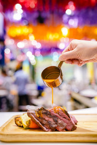 Close-up of hand holding drink on table