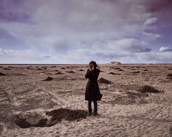 Full length of woman standing on land against sky