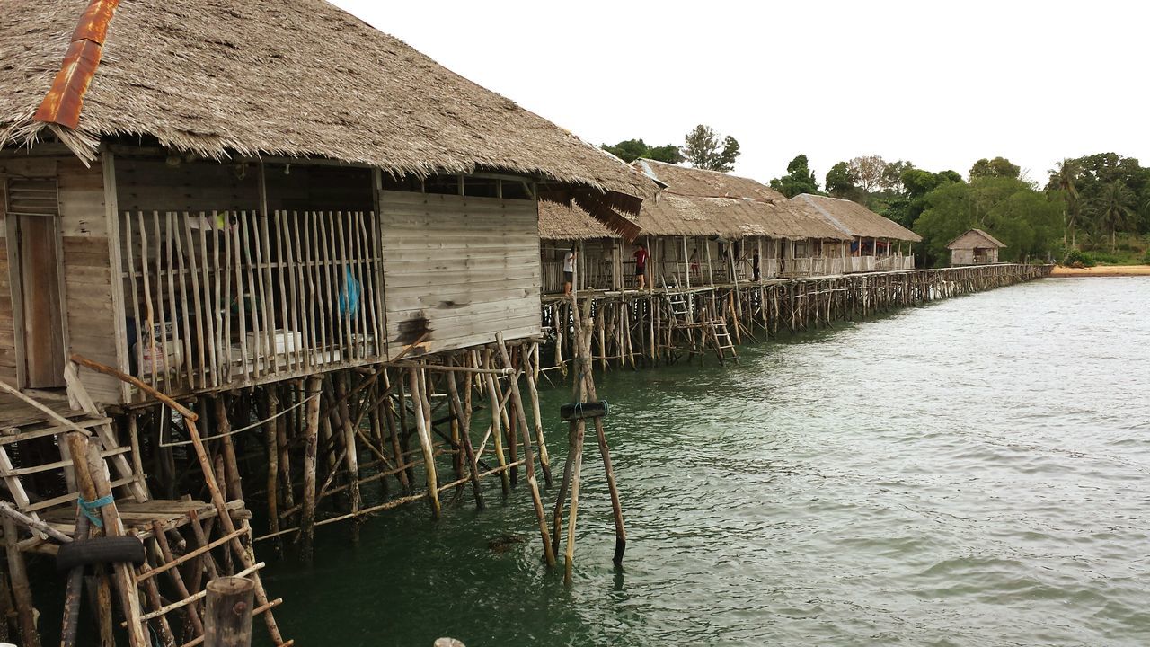 architecture, built structure, building exterior, water, stilt, stilt house, house, outdoors, thatched roof, day, waterfront, roof, no people, nature