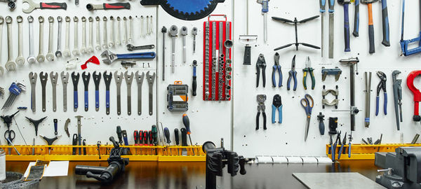 Kit of various professional repair instruments hanging on wall near workbench in garage