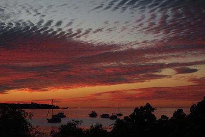 Scenic view of sea against dramatic sky during sunset