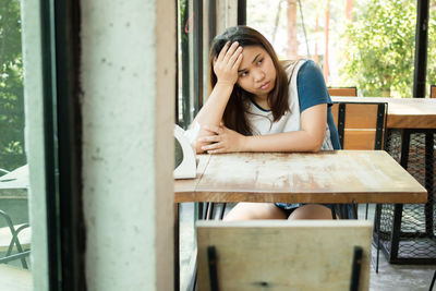 Depressed woman sitting at table in cafe