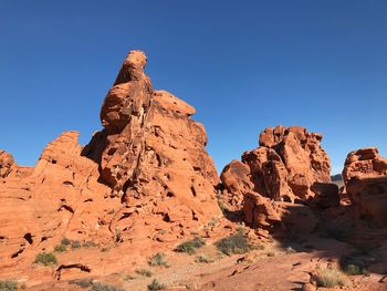 Low angle view of rock formation against clear blue sky